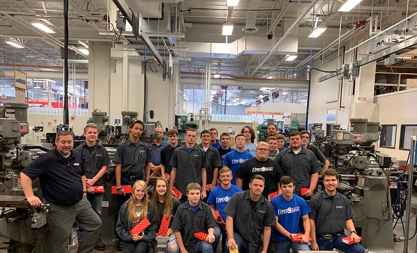 French Manager of Manufacturing, Ryan Hicks, poses with Upper Valley Career Center Machining and Manufacturing Students showing their new calipers